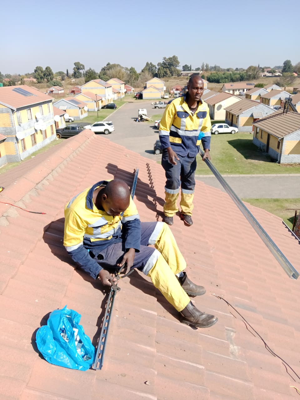 Solar installation team positioning panels on a roof