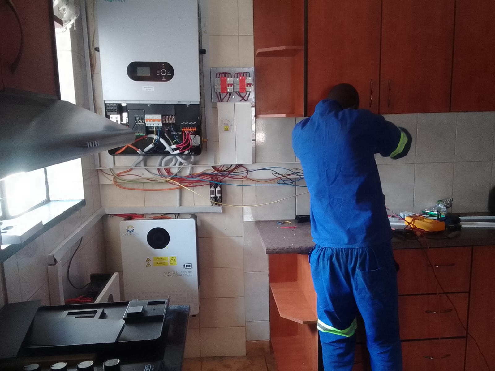 Technician wiring an inverter and backup power system