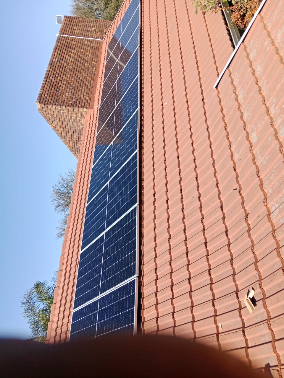 Roof-mounted solar panels installed along a brick building